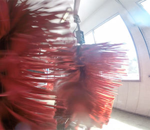 Red spinning brushes in motion inside of the carwash.
