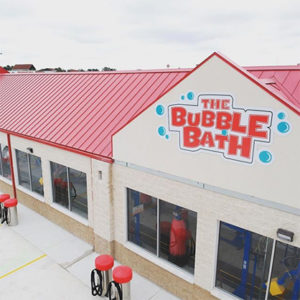 View of the outside of the car wash with the Bubble Bath logo.